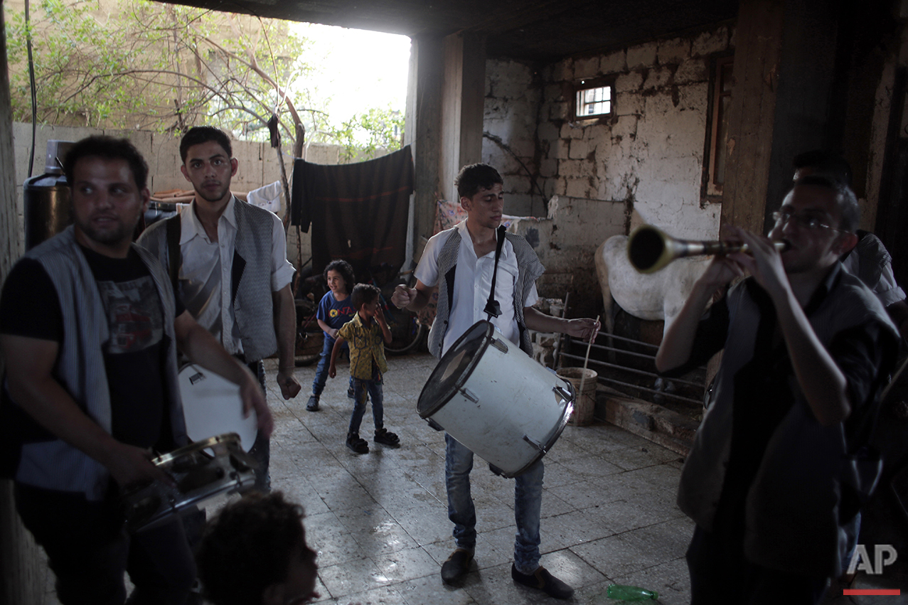  In this Saturday, July 31, 2016 photo, members of a drums band play music in the family house of Palestinian groom Saed Abu Aser as part of the preparations for his wedding party in Gaza have emerged as a welcome celebration that slices through the 