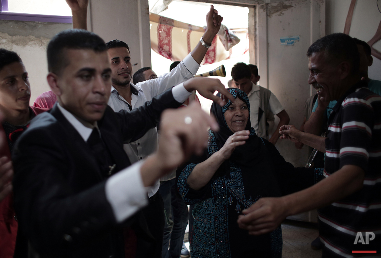 In this Saturday, July 30, 2016 photo, Palestinian groom Saed Abu Aser, second left, dances with his relatives in the family house during his wedding party, in Gaza City. (AP Photo/ Khalil Hamra) 