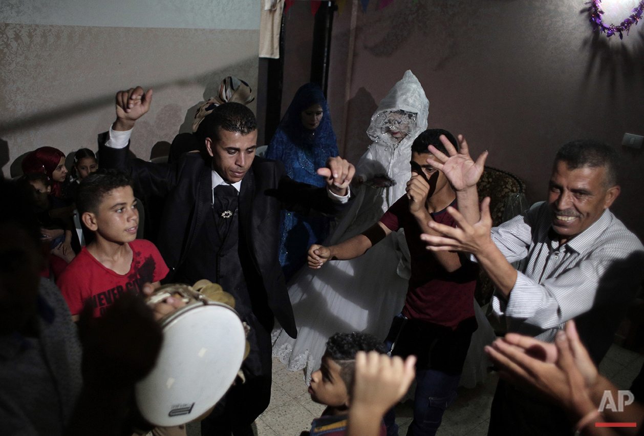  In this Saturday, July 31, 2016 photo, Palestinian groom Saed Abu Aser and relatives danc in front of his bride, Falasteen, in her family house during his wedding party in Gaza City. (AP Photo/Khalil Hamra) 