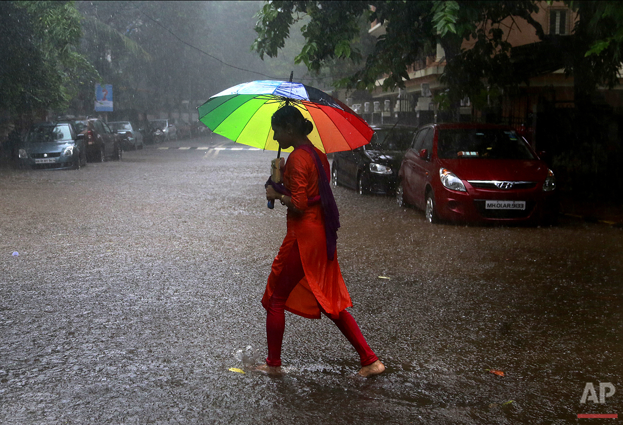  In this Friday, Aug. 5, 2016, photo, an Indian woman holds an umbrella and walks through the rain in Mumbai, India. Monsoon season in India begins in June and ends in October. (AP Photo/Rafiq Maqbool) 