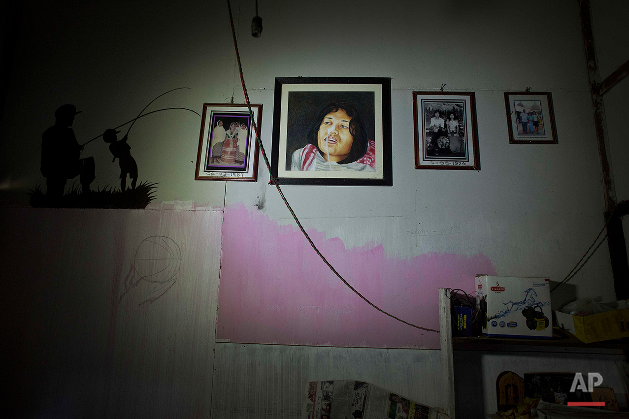  A portrait of Irom Sharmila, center, hangs on a wall with other family photographs at her home in Imphal, northeastern Manipur state, India, Monday, Aug.8, 2016. The 44-year-old activist who has been on a hunger strike for nearly 16 years to protest