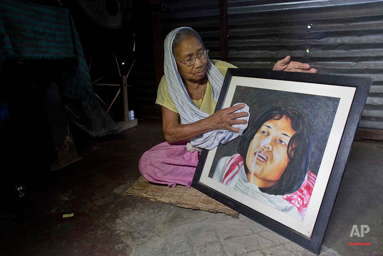  Irom Sakhi Devi, 84, mother of Indian activist Irom Sharmila, holds and cleans a portrait of her daughter as media persons interview her at her home in Imphal, northeastern Manipur state, India, Monday, Aug.8, 2016. Sharmila, the 44-year-old activis