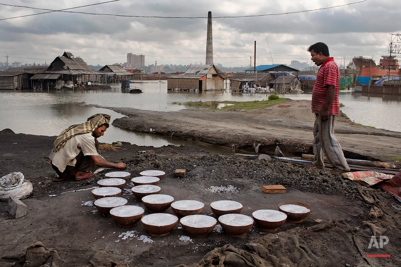 In this Aug. 3, 2016 photo, laborers work at an aluminum recycling factory on the outskirts of Dhaka, Bangladesh. A large swath of land not far from the Buriganga River is dotted with makeshift tents that are home to men and women who travel far from home to work 12 hours a day recycling cans, industrial ash and medicine blister packets into raw aluminum. The work is difficult and dangerous. The workers have no safety equipment or masks to protect themselves from the fumes and aluminum dust. (AP Photo/A.M. Ahad)