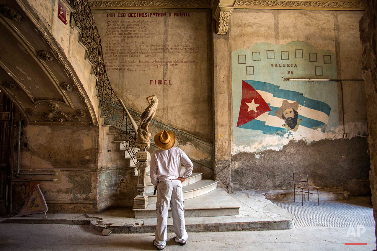  A tourist looks at quote by Cuban Revolution leader Fidel Castro explaining in Spanish, 'Why we say homeland or death," on a wall at the entrance of a landmark private restaurant  in Havana, Cuba, Thursday, July 28, 2016. After a decade out of the p