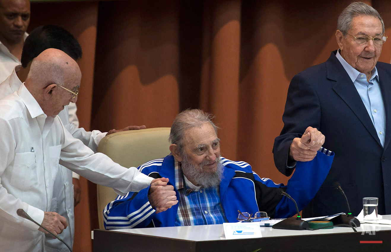  In this Tuesday, April 19, 2016 photo, Fidel Castro sits as he clasps hands with his brother, Cuban President Raul Castro, right, and second secretary of the Central Committee, Jose Ramon Machado Ventura, moments before the playing of the Communist 