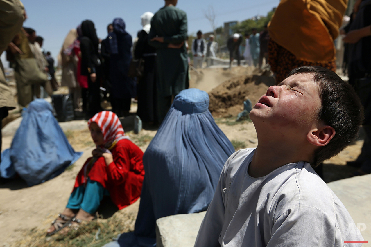  The brother of Zarah, a pregnant 14-year-old who died after she was set on fire in her husband's home, sits with other mourners at her funeral in Kabul, Afghanistan, on Wednesday, Aug. 10, 2016. Zarah was allegedly tortured and set on fire by her hu