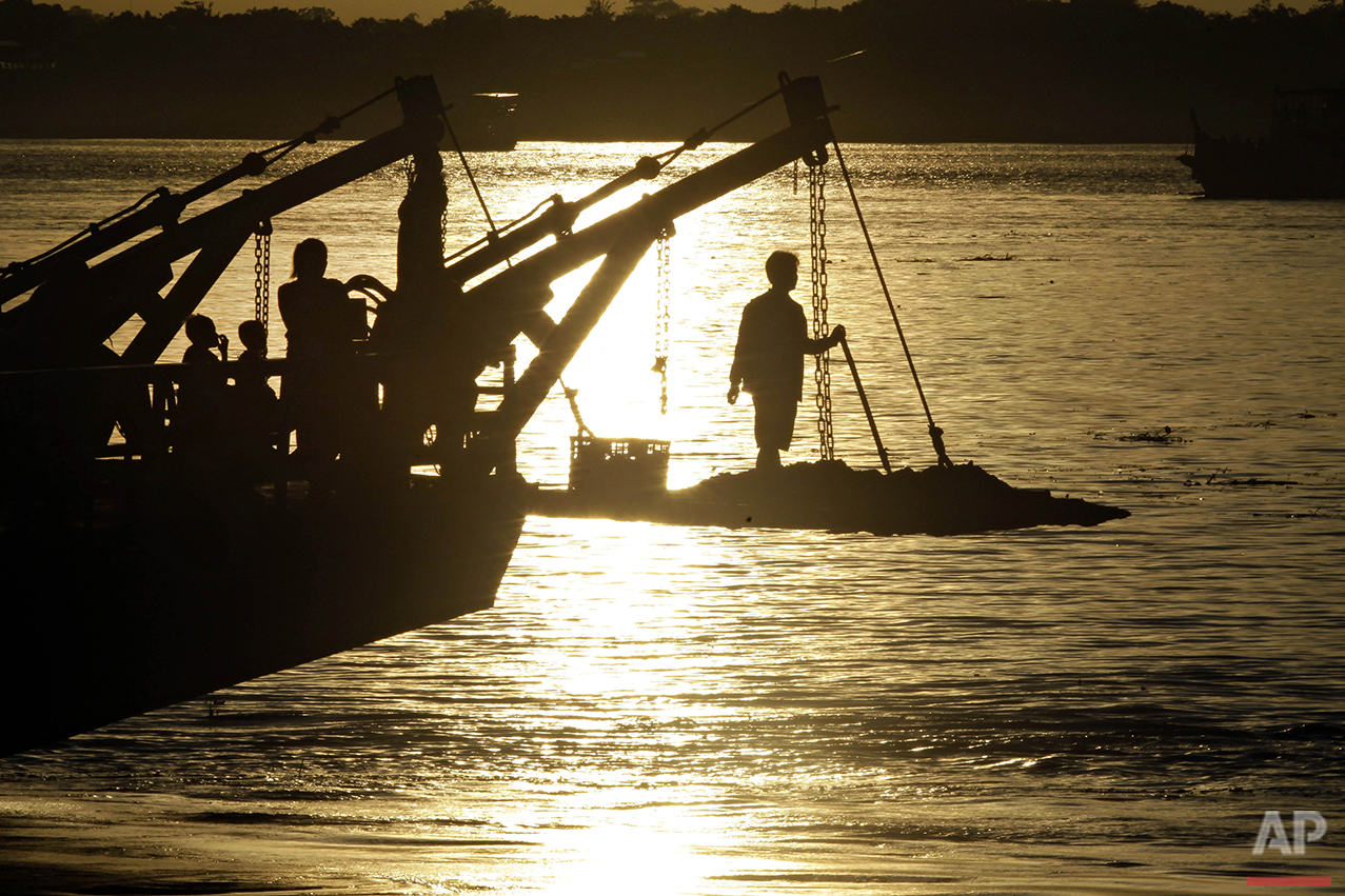 A passenger stands on the foredeck of a ferry as it crosses the Mekong river from Arey Ksat to the main part of Phnom Penh, Cambodia, Friday, July 1, 2016. Ferries are used daily to transport villagers and products over the Mekong and Tonle Sap rivers from Arey Ksat to Phnom Penh. (AP Photo/Heng Sinith)