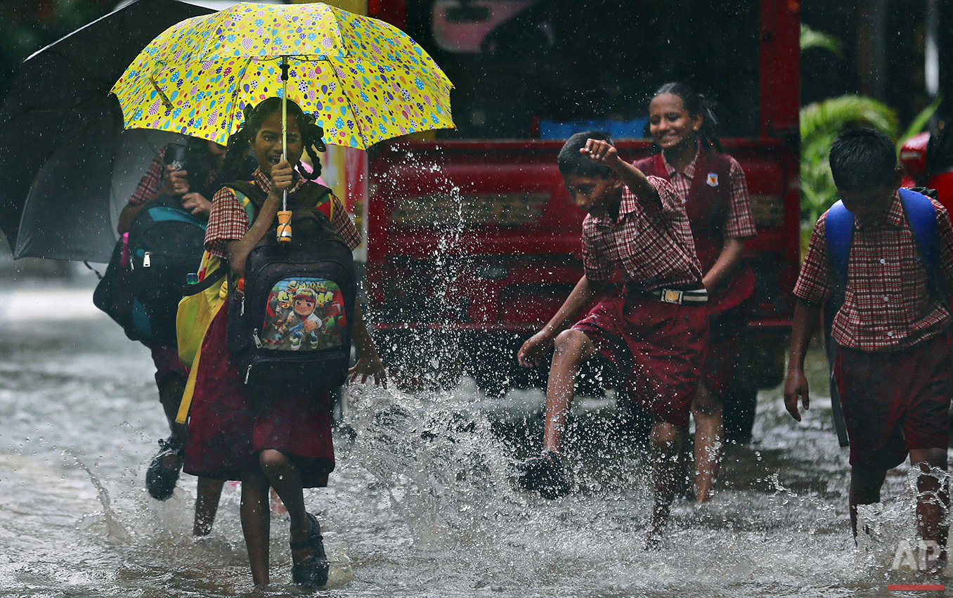 A girl reacts to a boy splashing water on her on a flooded street in Mumbai, India, Tuesday, June 28, 2016. India's monsoon season runs from June to September. (AP Photo/Rafiq Maqbool)