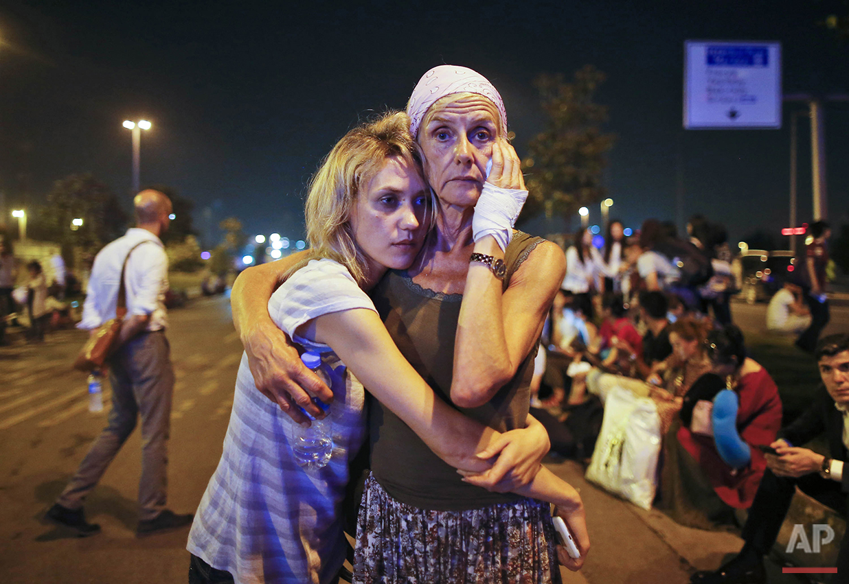 Passengers embrace each other as they wait outside Istanbul's Ataturk airport, early Wednesday, June 29, 2016 following their evacuation after a blast. Suspected Islamic State group extremists have hit the international terminal of Istanbul's Ataturk airport, killing dozens, Turkish officials said Tuesday. Turkish authorities have banned distribution of images relating to the Ataturk airport attack within Turkey. (AP Photo/Emrah Gurel)