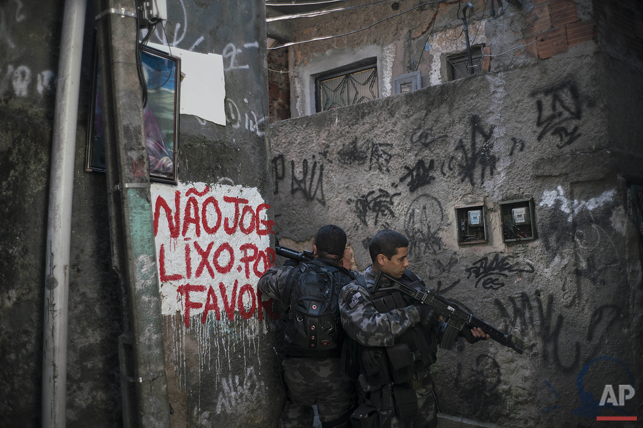 Officers take positions during a police operation against drug traffickers in the Jacarezinho slum of Rio de Janeiro, Wednesday, June 29, 2016. Recent violence is adding to worries about safety in Rio during the Olympics. Officials have warned that budget shortfalls may compromise security during the games. (AP Photo/Felipe Dana)