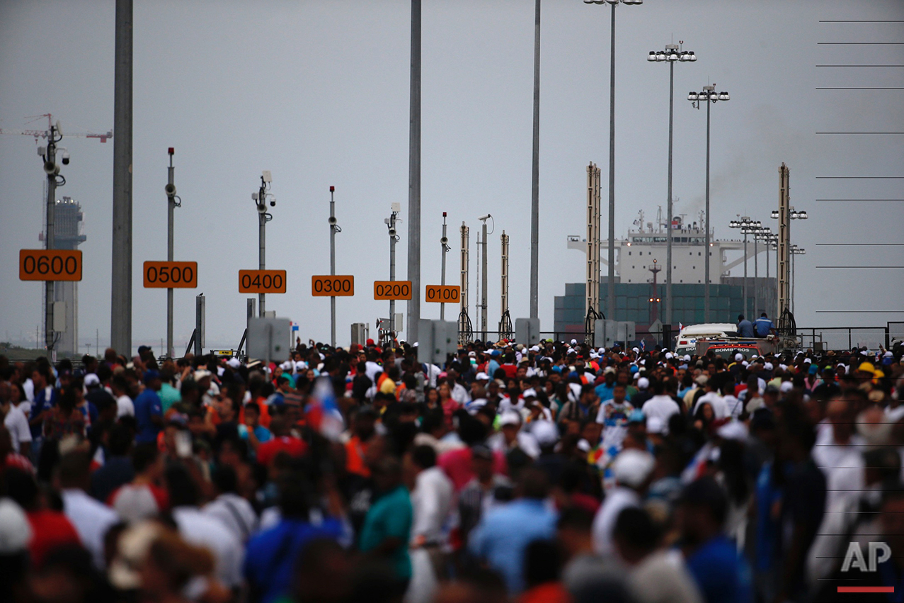 Thousands watch as the Neopanamax cargo ship, Cosco Shipping Panama, prepares to cross the new Agua Clara locks, part of the Panama Canal expansion project, near the port city of Colon, Panama, Sunday June 26, 2016. The ship, carrying more than 9,000 containers, entered the newly expanded locks that will double the Panama Canal's capacity in a multibillion-dollar bet on a bright economic future despite tough times for international shipping. (AP Photo/Moises Castillo)