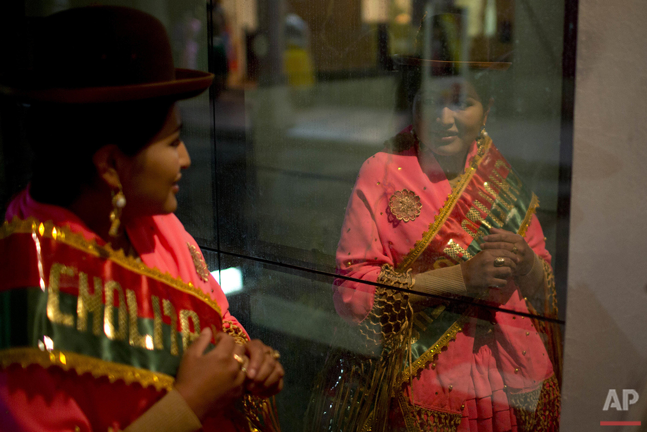  An Aymara woman looks at her reflection as she prepares to compete in the Miss Cholita 2016 pageant in La Paz, Bolivia, Friday, July 1, 2016. Cholita is the style of clothing worn by many of the country's indigenous women. (AP Photo/Juan Karita) 