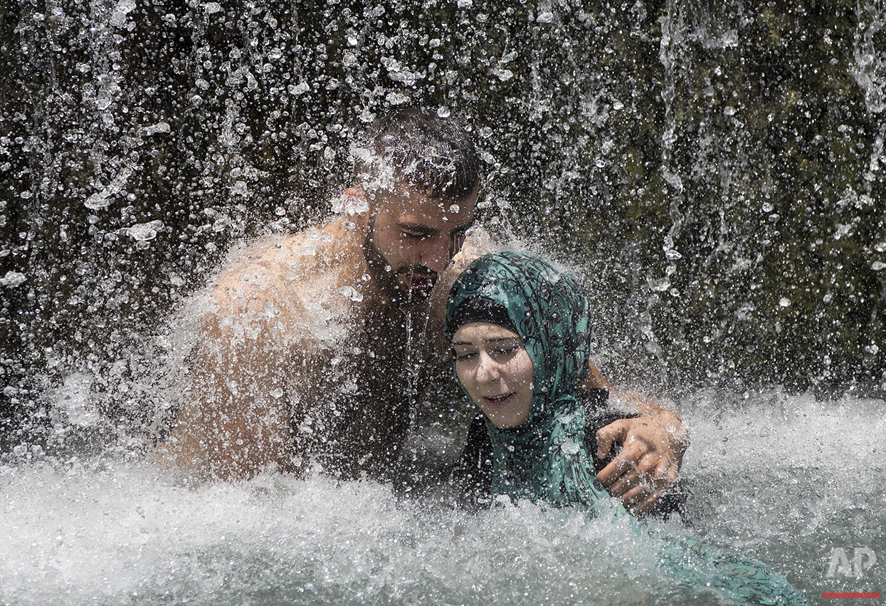  Israeli Arabs stand under a waterfall during the Eid al-Fitr holiday at the Gan HaShlosha national park near the northern Israeli town of Beit Shean, Friday, July 8, 2016. Eid al-Fitr marks the end of the Muslim holy fasting month of Ramadan. (AP Ph