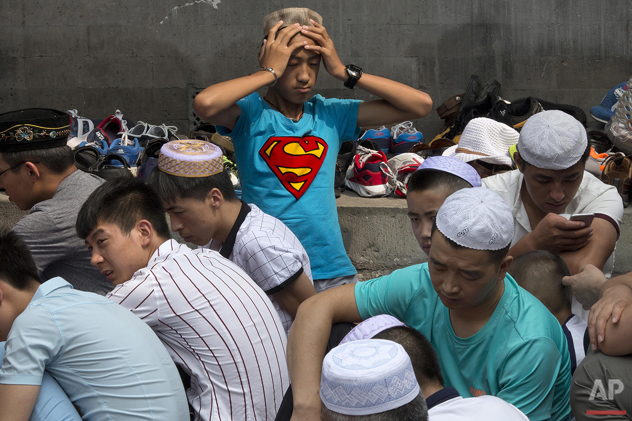  A man rubs his head during Eid al-Fitr prayers at the Niujie mosque, the oldest and largest mosque in Beijing, Wednesday, July 6, 2016. The Eid al-Fitr celebrations mark the end of the Muslim holy fasting month of Ramadan. (AP Photo/Ng Han Guan) 