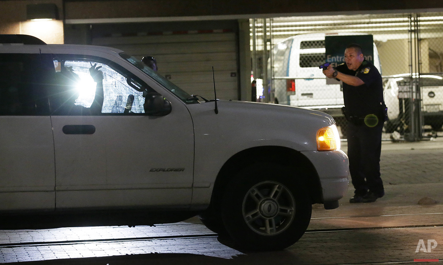  A police officer stops a driver in downtown Dallas on Thursday, July 7, 2016 after police officers were shot and killed during a protest over fatal police shootings of black men in other states. (AP Photo/LM Otero) 