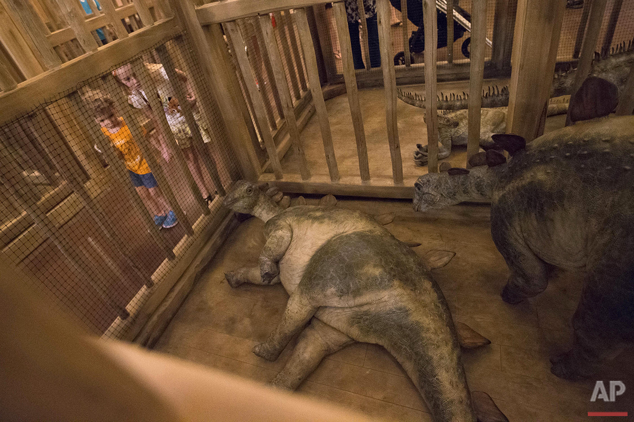  Children look into a cage containing model baby dinosaurs inside a replica of Noah's Ark at the Ark Encounter theme park during a media preview day in Williamstown, Ky., Tuesday, July 5, 2016. The exhibit based on the story of Noah, who got a warnin