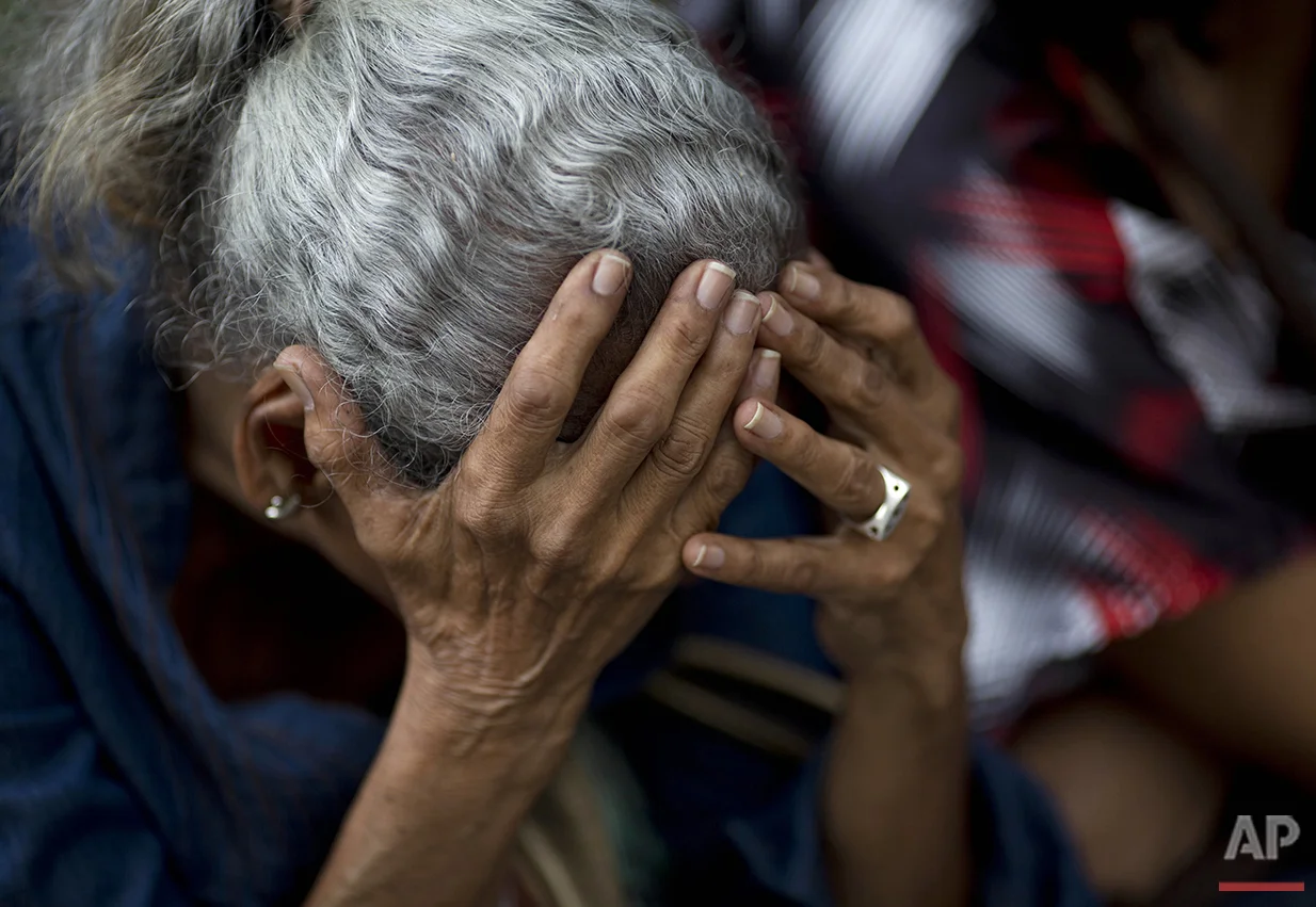  In this Tuesday, May 3, 2016 photo, a woman holds her head as she waits in line outside a supermarket to buy food in Caracas, Venezuela. Nine out of 10 people here say they can’t buy enough to eat, according to a study by Simon Bolivar University. (