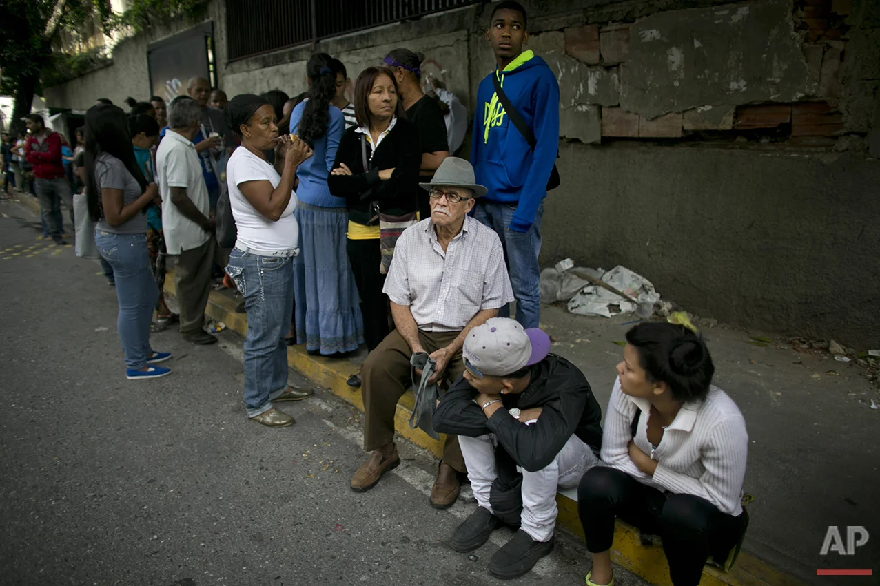  In this Monday, July 4, 2016 photo, people wait in line to buy food outside a supermarket in Caracas, Venezuela. The extent of the country’s economic collapse can be measured in the length of the lines snaking through every neighborhood. (AP Photo/A