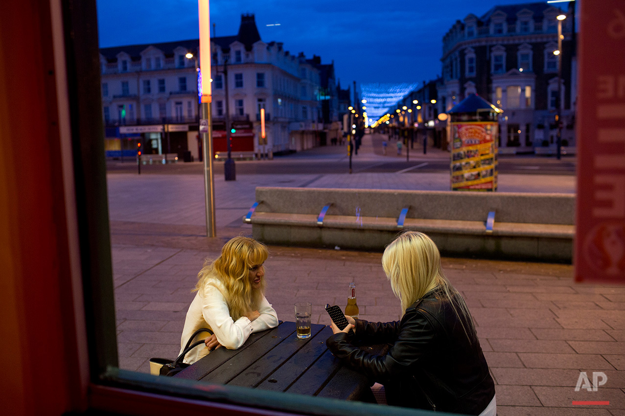  In this Wednesday, July 6, 2016 photo, two woman sit outside a pub at Great Yarmouth, East of England. On a rare blue-sky day in Great Yarmouth, a quintessentially English seaside resort with squeaky-floored hotels and screeching seagulls, the mostl