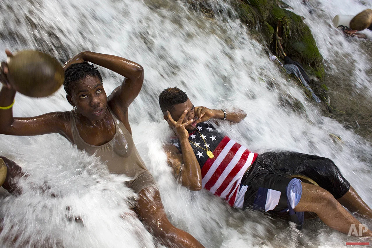 Voodoo pilgrims bathe in a waterfall believed to have purifying powers during the annual celebration in Saut d' Eau, Haiti, on Saturday, July 16, 2016. After bathing, worshippers throw away the dresses they wore to the site, and don new clothes for good luck. (AP Photo/Dieu Nalio Chery)