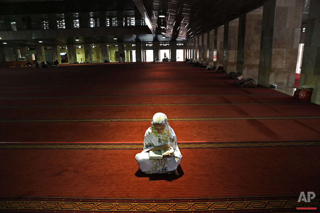  A Muslim woman reads the Quran following noon prayers on the first day of the holy fasting month of Ramadan at Istiqlal Mosque in Jakarta, Indonesia, Monday, June 6, 2016. During Ramadan, the holiest month on Islamic calendar, Muslims refrain from e