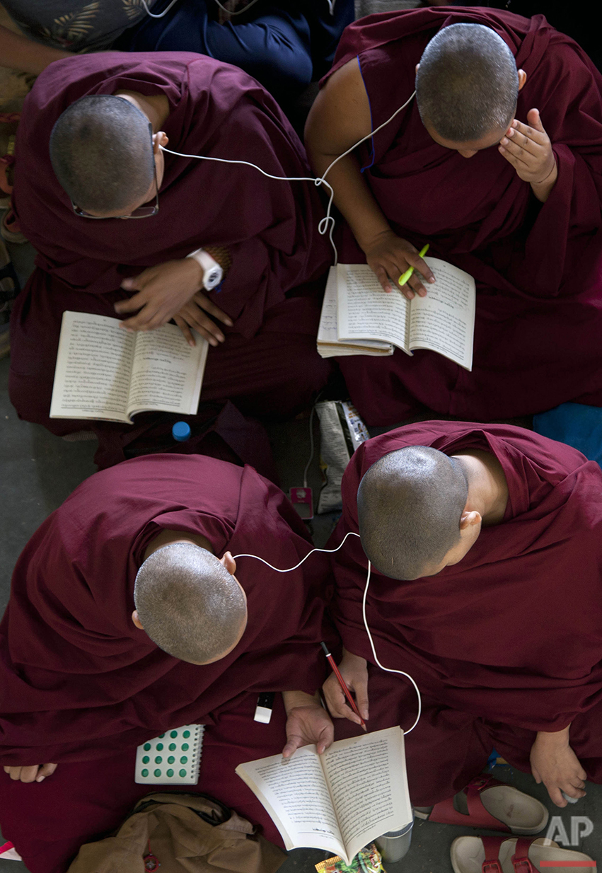  Exiled Tibetan Buddhist nuns read a religious text as they use headphones to listen to their spiritual leader, the Dalai Lama, during a religious talk at the Tsuglakhang temple in Dharmsala, India, Thursday, June 9, 2016. (AP Photo /Ashwini Bhatia) 