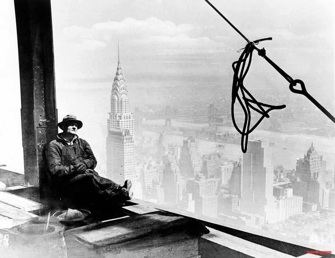 A steel worker rests on a girder at the 86th floor of the new Empire State Building during construction in New York City, Sept. 24, 1930. The tower of the Chrysler Building can be seen in the background on left. (AP Photo)