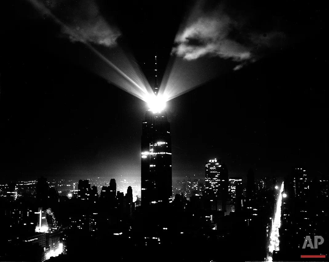 A new beacon light atop the Empire State Building in New York City, visible for 80 miles, lights up clouds as they revolve during a test on April 11, 1956. The glow at left of the building is from Times Square. Madison Ave., is at right. (AP Photo)