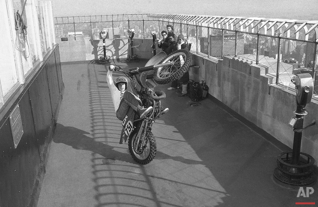 Doug Domokos, 26, of Anaheim, Calif., does a wheelie atop the observation roof of the Empire State Building in New York on Tuesday, Feb. 1, 1983, to inaugurate his first appearance in New York at the opening of "The Great American Motorcycle Show" at Madison Square Garden. (AP Photo/Marty Lederhandler)