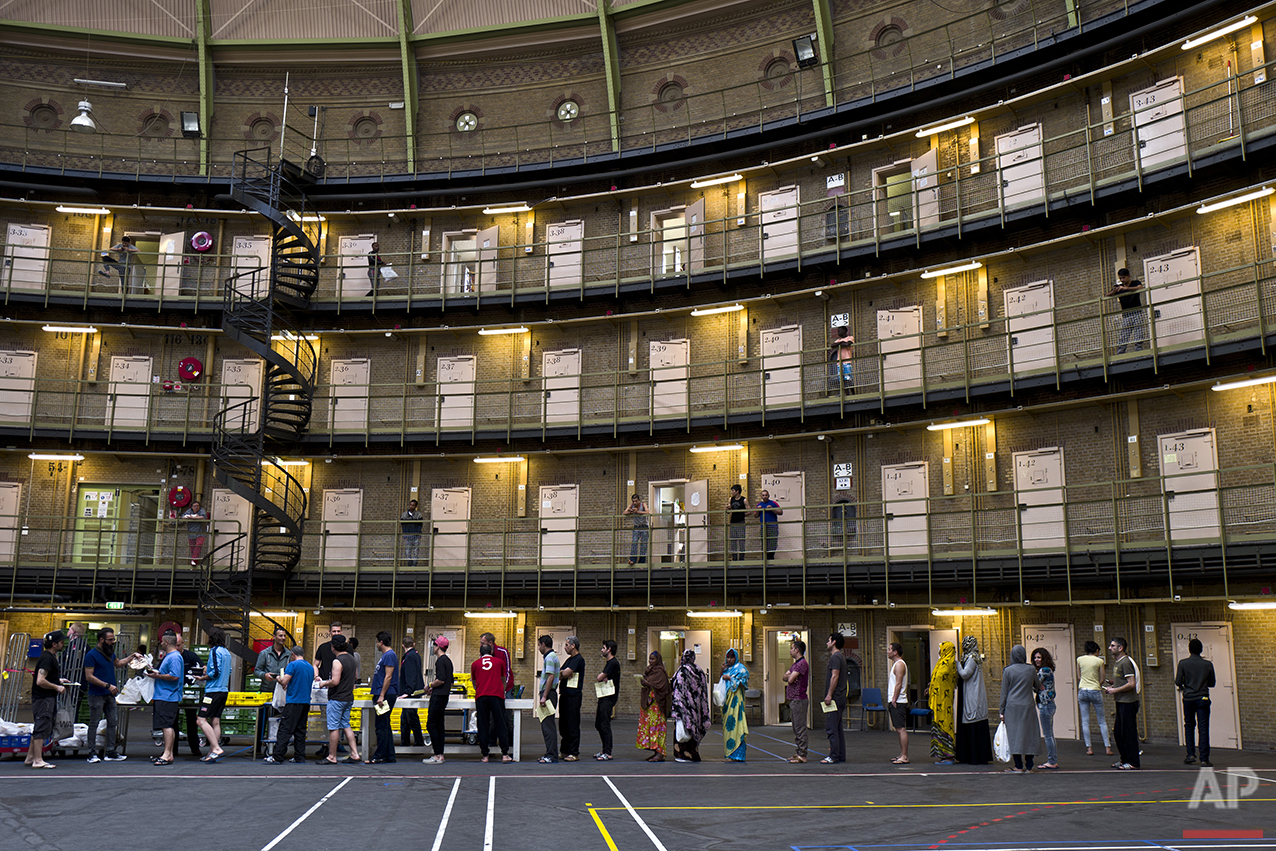  In this Wednesday, April 20, 2016 photo, refugees and migrants line up to receive their lunch at the former prison of De Koepel in Haarlem, Netherlands. (AP Photo/Muhammed Muheisen) 