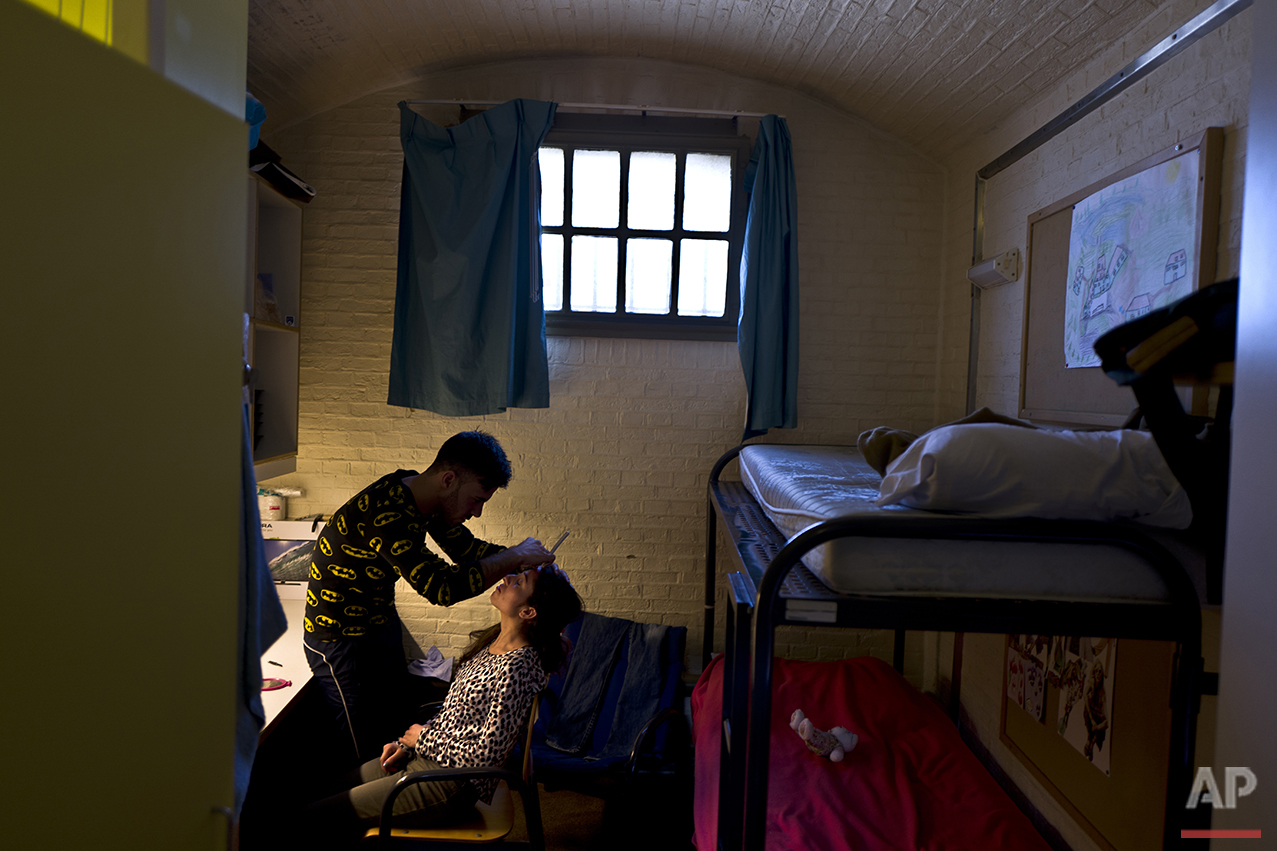  In this Sunday, May 1, 2016 photo, Yazidi refugee Yassir Hajji, 24, from Sinjar, Iraq, adjusts the eyebrow of his wife Gerbia,18, in their room in the former prison of De Koepel in Haarlem, Netherlands. (AP Photo/Muhammed Muheisen) 