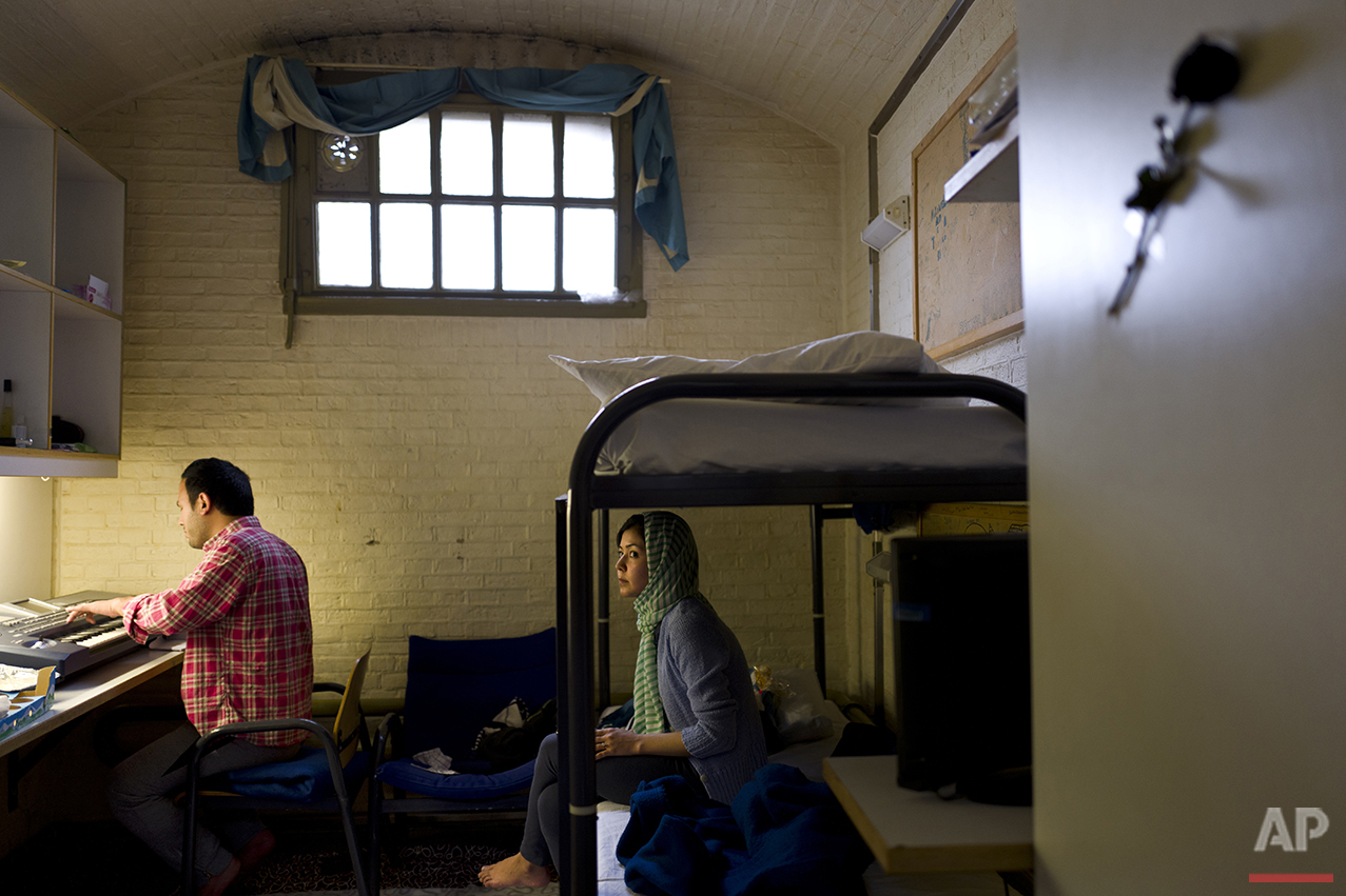  In this Wednesday, April 6, 2016 photo, Afghan refugee Hamed Karmi, 27, plays keyboard next to his wife Farishta Morahami, 25, sitting on a bed inside their room at the former prison of De Koepel in Haarlem, Netherlands. (AP Photo/Muhammed Muheisen)