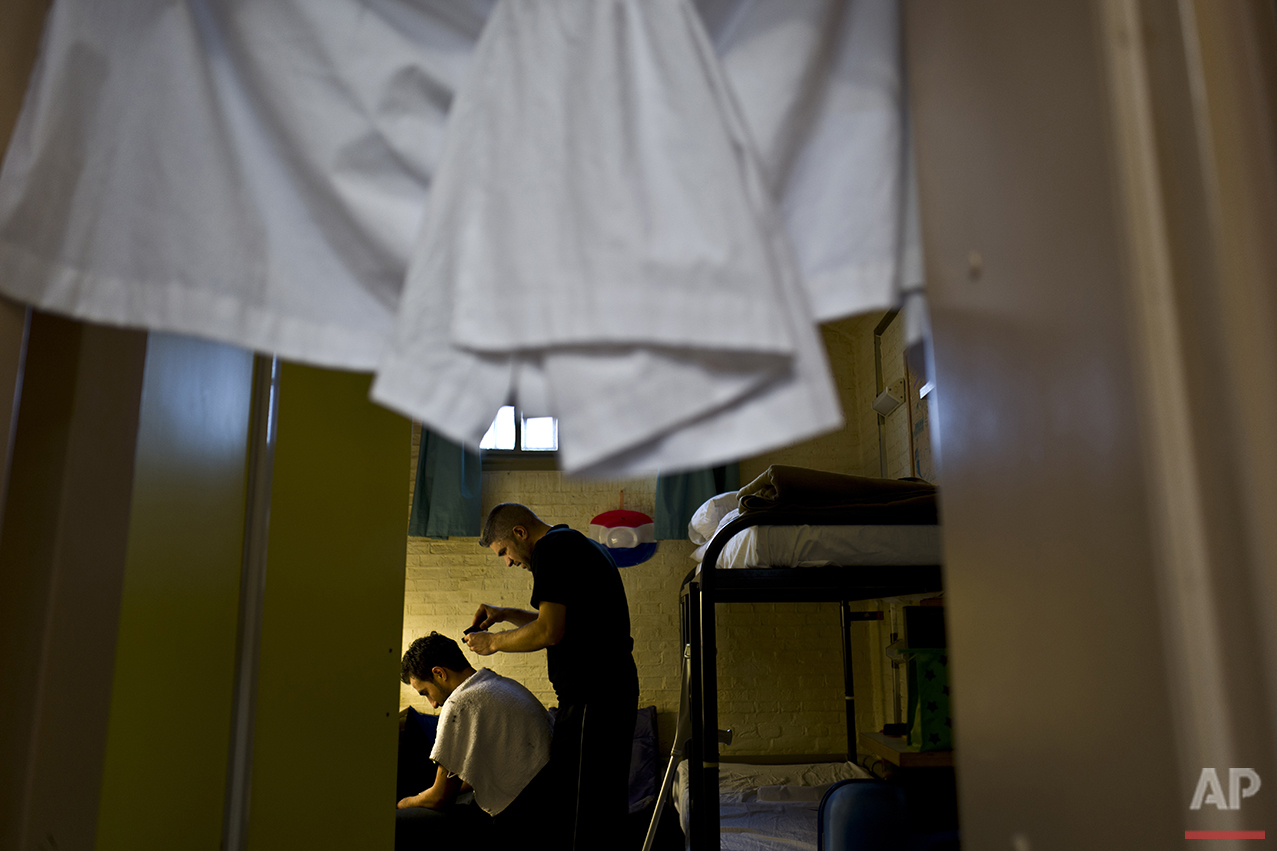  In this Thursday, April 21, 2016 photo, Syrian refugee Imad Abdulrahman, 30, gives a haircut to another Syrian refugee in a room at the former prison of De Koepel in Haarlem, Netherlands. (AP Photo/Muhammed Muheisen) 