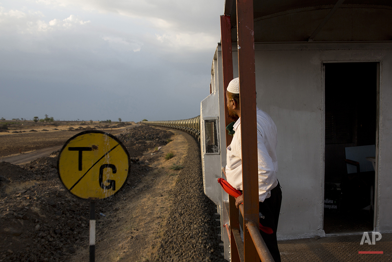  In this May 9, 2016, photo, Sikandar Nabi Sahab, guard of the Jaldoot water train, peers out from his cabin as the train rolls out of the Miraj railway station, Miraj, 340 kilometes (211 miles) from Latur, in the Indian state of Maharashtra. Many tr