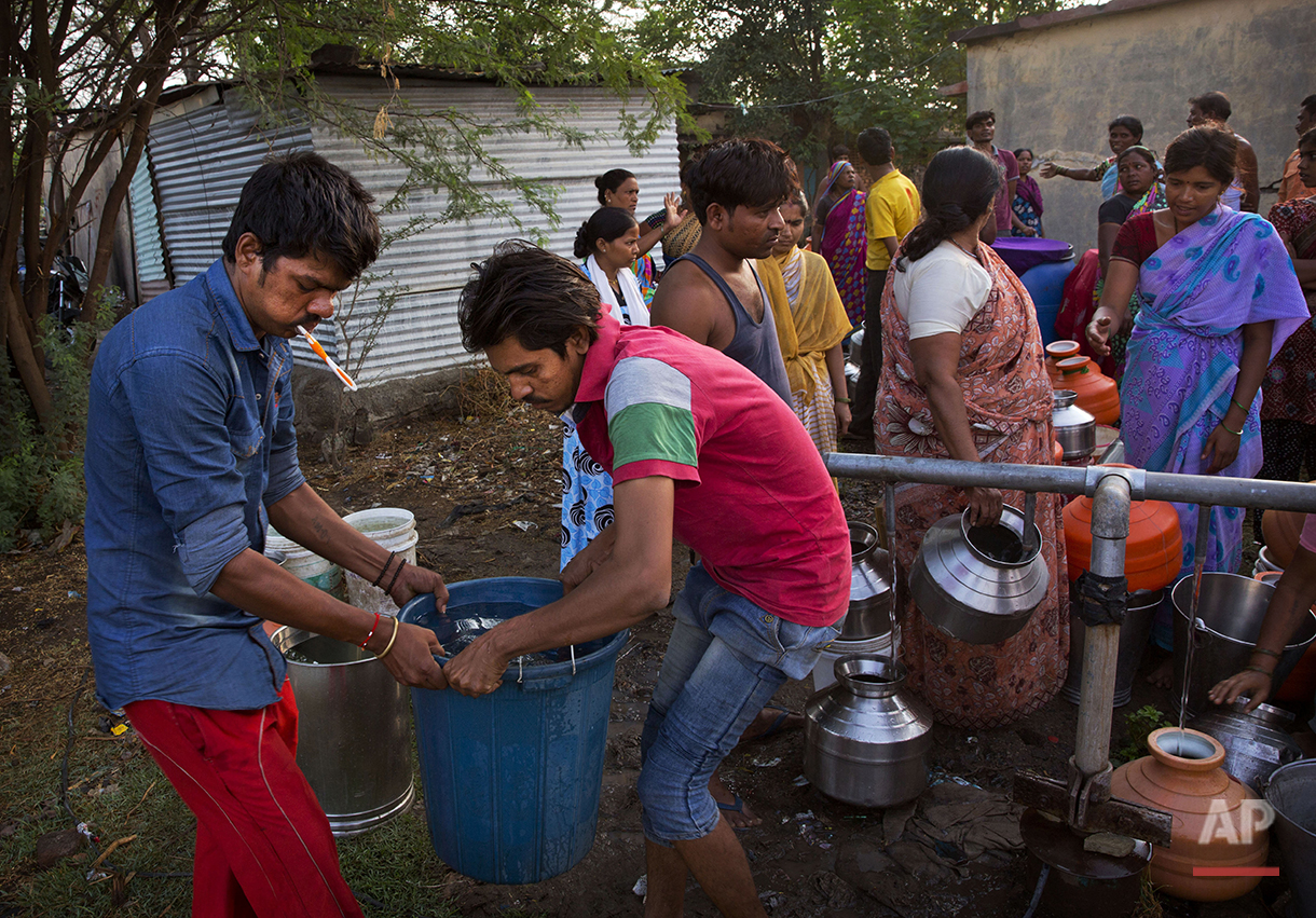  In this May 10, 2016, photo, residents of a shanty town fill water from municipal taps which are supplied by the Jaldoot water train in Latur, in the Indian state of Maharashtra. Many trains pull into Latur's railroad station but none is as eagerly 