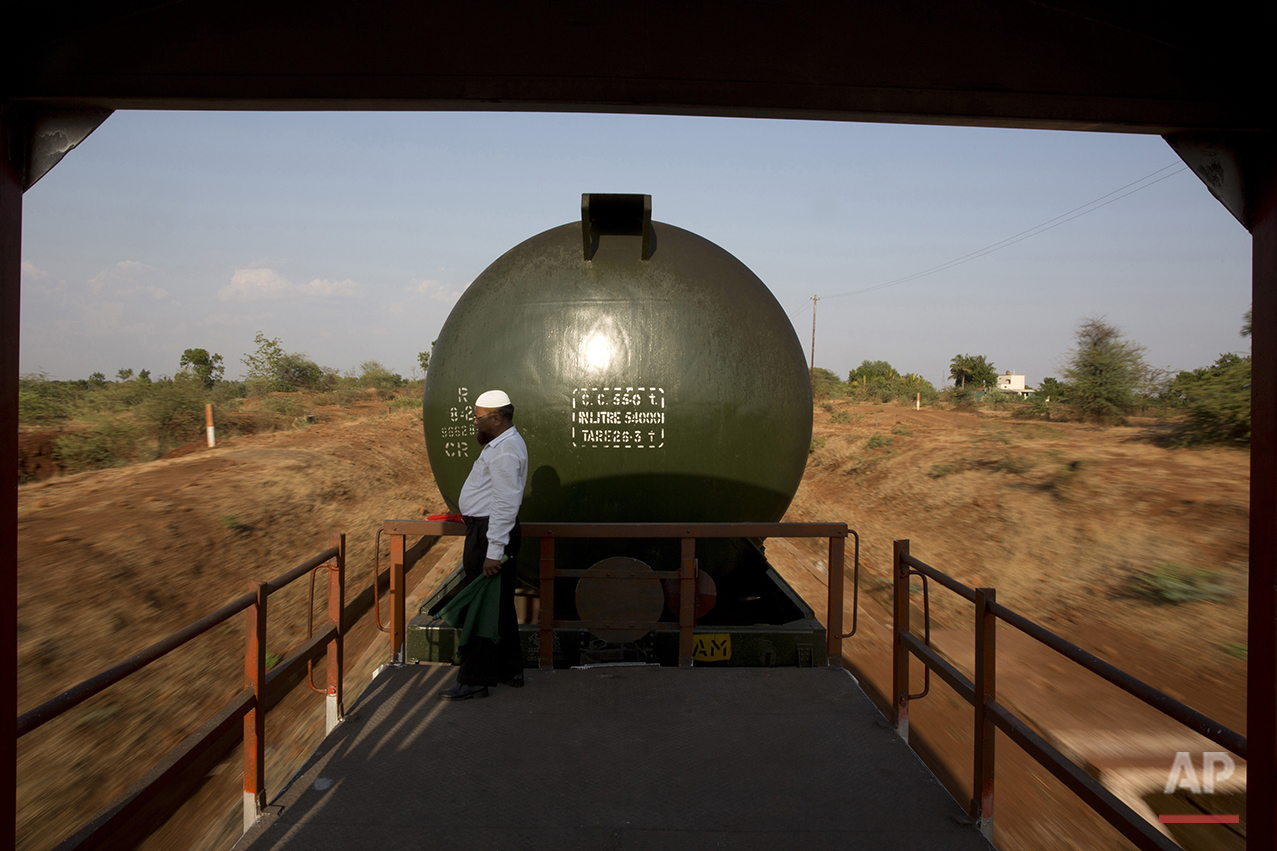  In this May 9, 2016, photo, Sikandar Nabi Sahab, guard of the Jaldoot water train, looks out at the parched lands from a platform as the train rolls out of Miraj railway station, Miraj,  340 kilometers (211 miles) from Latur, in the Indian state of 