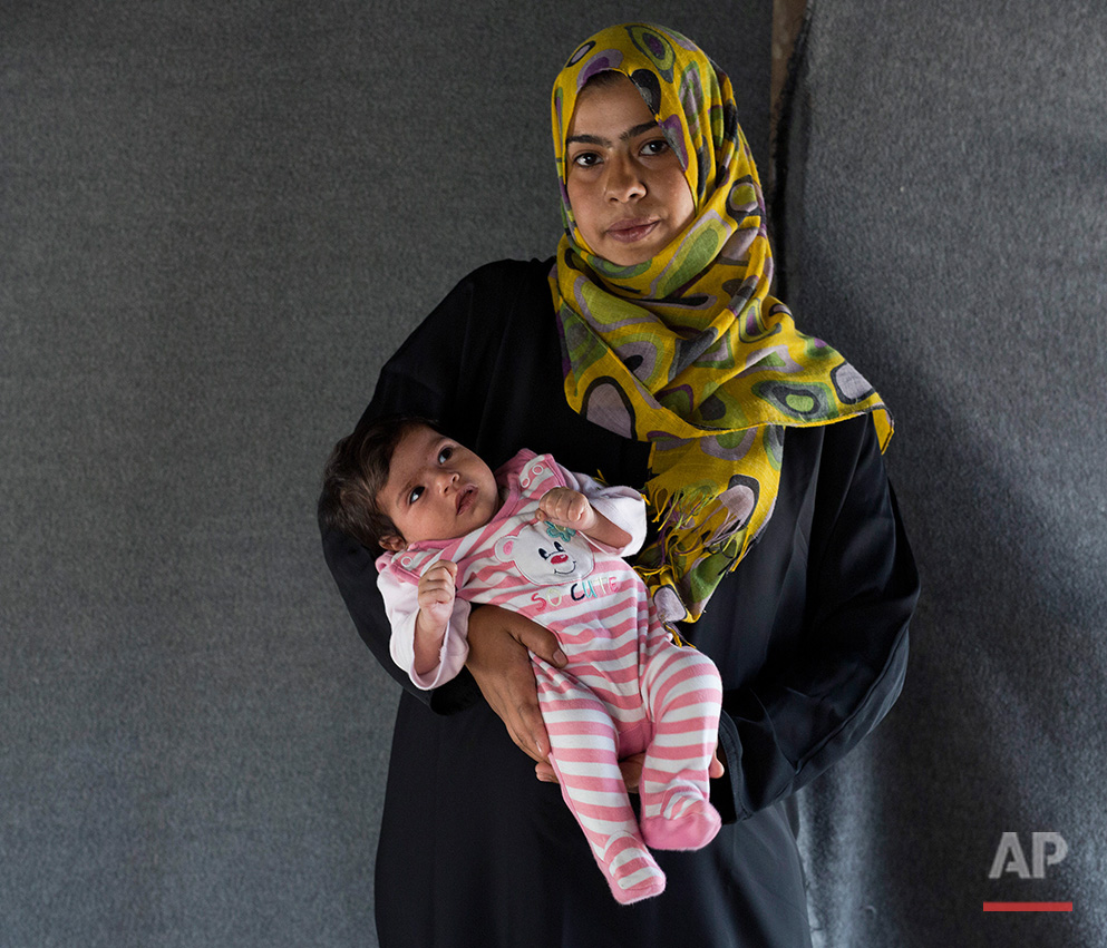   In this picture made on Sunday, May 15, 2016, 24-year-old Asmaa, a Syrian mother from Damascus, poses with her baby girl Jana in a tent made of blankets given by the UNCHR at the refugee camp of the northern Greek border point of Idomeni. Asmaa is 