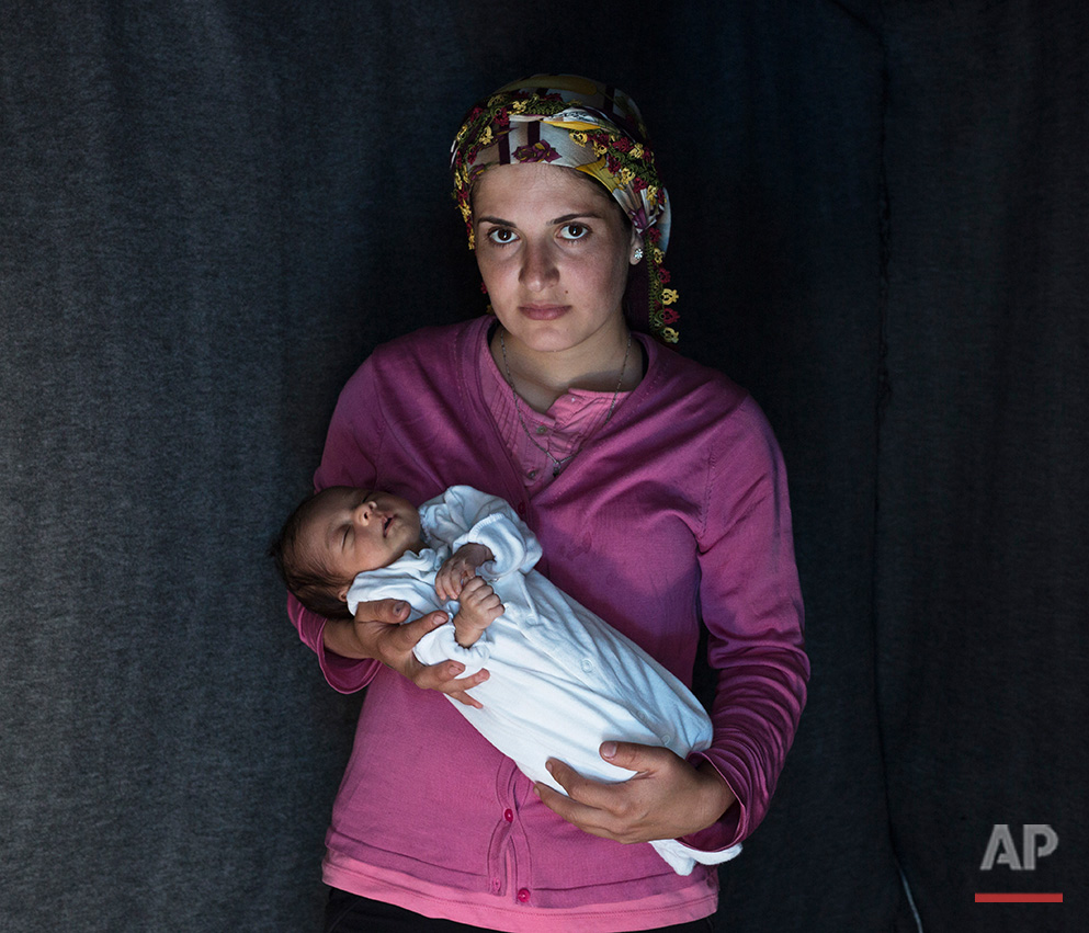   In this picture made on Friday, May 16, 2016, 23-year-old Rojin, a Kurdish-Syrian mother from the city of Qamishli, Syria  poses with her baby girl Beritan in a tent made of blankets given by the UNCHR at the refugee camp of the northern Greek bord