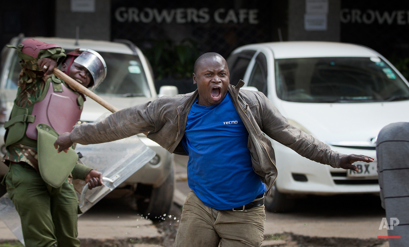  An opposition supporter yells out as he is beaten with a wooden club by riot police while trying to flee, during a protest in downtown Nairobi, Kenya Monday, May 16, 2016. Kenyan police have tear-gassed and beaten opposition supporters during a prot