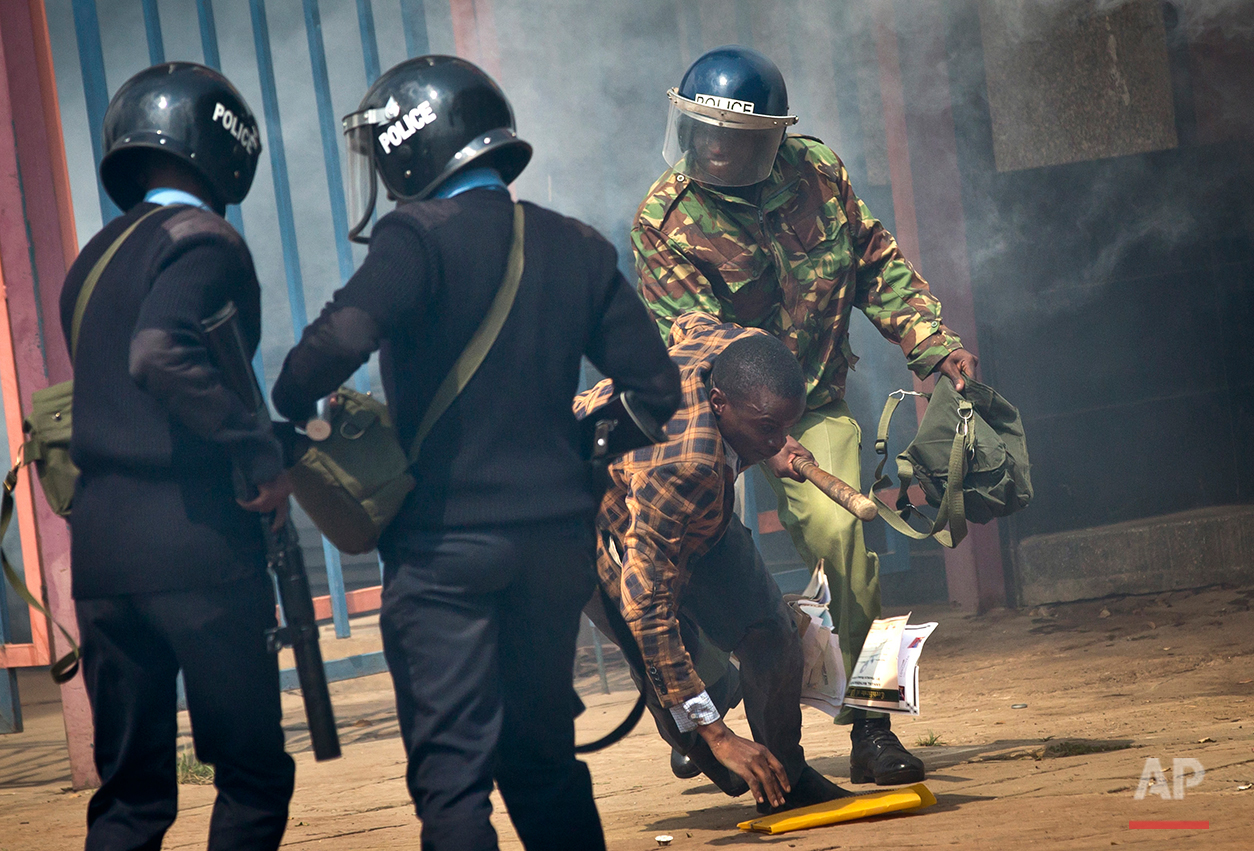  An opposition supporter is beaten with a wooden club by riot police as he tries to flee, during a protest in downtown Nairobi, Kenya Monday, May 16, 2016. Kenyan police have tear-gassed and beaten opposition supporters during a protest demanding the