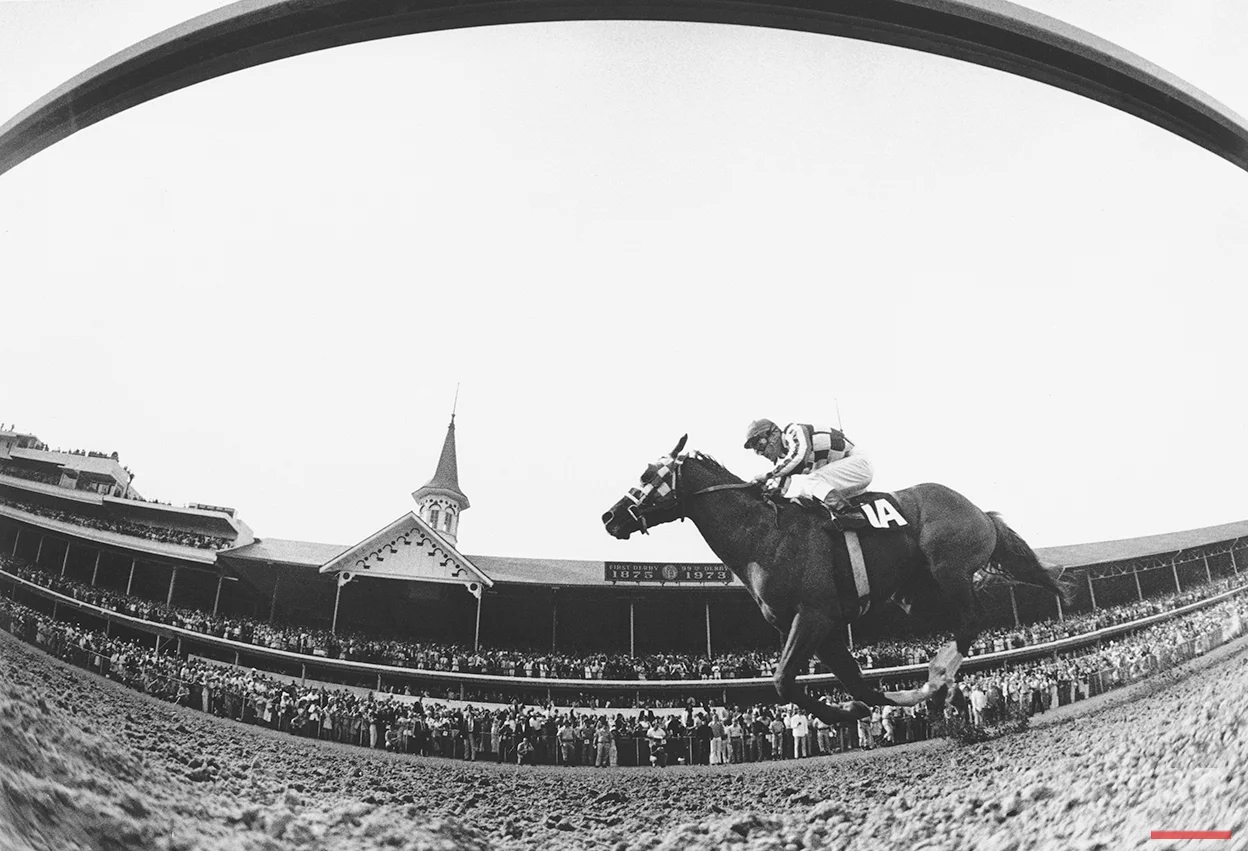 This is a fish-eye lens view of Secretariat, ridden by Ron Turcotte, thundering past the packed clubhouse at Churchill Downs, Louisville, Ky., to win the 1973 Kentucky Derby May 5, 1973. (AP Photo)