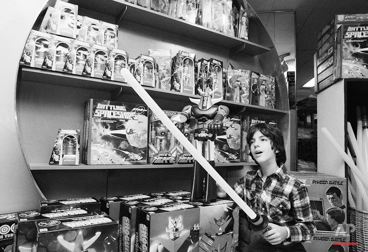  Haik Gazarian, 11, from Caracas, Venezuela, who now lives in New York, tries to cut a toy "Force Wand,"  an illuminated toy sword inspired by the film "Stars Wars," during the visit to the toy department store, on Wednesday Dec. 22, 1977. In the bac