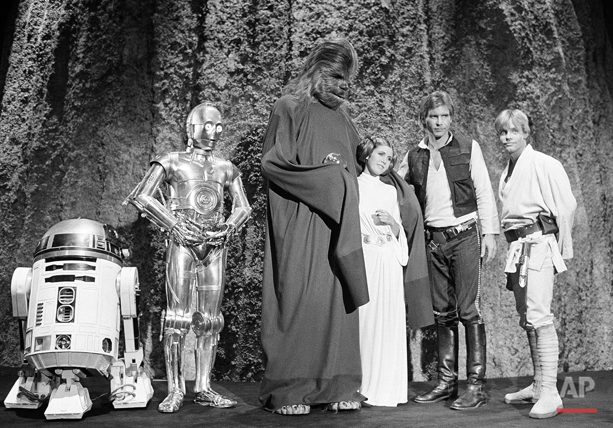 Harrison Ford, as Han Solo of “Star Wars” with Carrie Fisher in the filming of the CBS-TV special “The Star Wars Holiday” Nov. 13, 1978. Ford says he leaves the singing in the special to Carrie, who is the daughter of Eddie Fisher and Debbie Reynolds. The film will also feature many special effects not seen on the original movie. (AP Photo/George Brich)