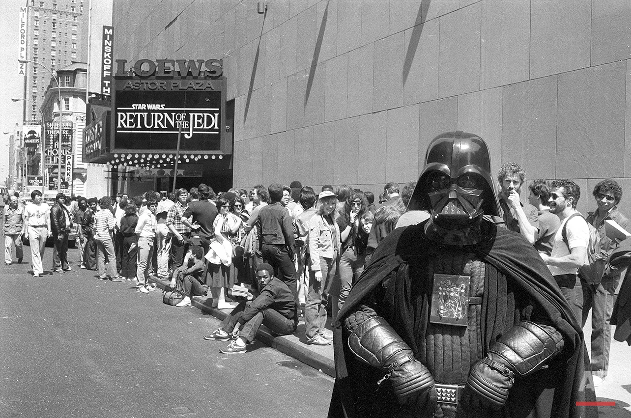 "Star Wars" fan Danny Fitzgerald of Staten Island, in Darth Vader costume, poses in front of Loews Astor Plaza movie theater in Times Square in New York, May 25, 1983, where fans are lined up for the premiere of "The Return of the Jedi," the third in a series of the "Star Wars" saga. (AP Photo/Dave Pickoff)