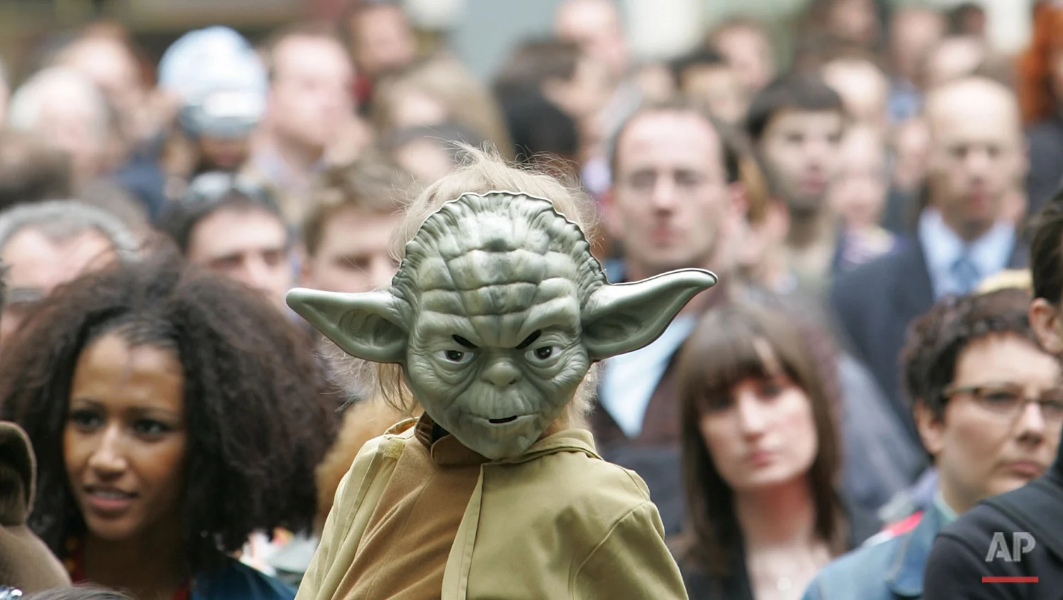 A young boy dressed as the Star Wars character 'Yoda' sits on the shoulders of a man as he watches events in Leicester Square in London and joins in with the premier launch of the film Star Wars Episode III Revenge of the Sith, Monday May 16, 2005. The film by American Director George Lucas is the last in the Star Wars series. (AP Photo/Alastair Grant)
