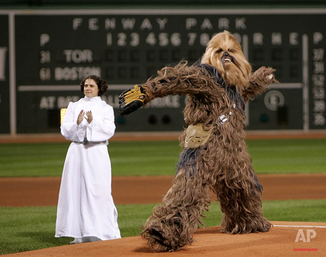 An actor playing Chewbacca throws out the ceremonial first pitch prior to a game between the Boston Red Sox and Toronto Blue Jays Fenway Park in Boston, Wednesday Sept. 28, 2005. Chewbacca and an actress playing Princess Leia were promoting the Star Wars: Where Science Meets Imagination exhibit at the Museum of Science in Boston. (AP Photo/Charles Krupa)