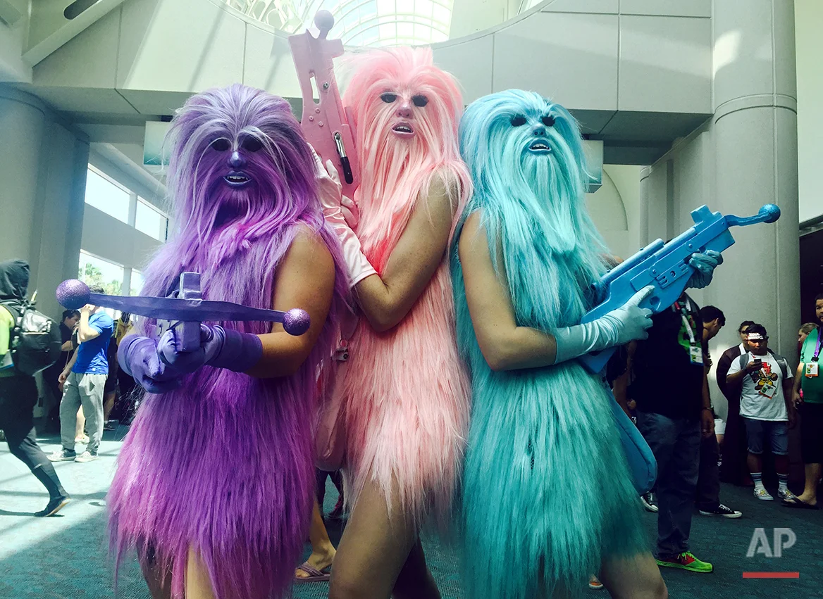 In this July 10, 2015 photo, fans dressed as "Chewie's Angels" attend day 2 of Comic-Con International, in San Diego, Calif. Star Wars” inspires curiously personal reactions. It drives some people to don Wookie costumes and others to curse an entire industry as infantile. Since the 1977 debut of “A New Hope,” it’s become a generational rite of passage not just to experience the saga, but to form one’s relationship with movies around it, whether in happy lockstep or rebel opposition. (Photo by Chelsea Vicari/Invision/AP)
