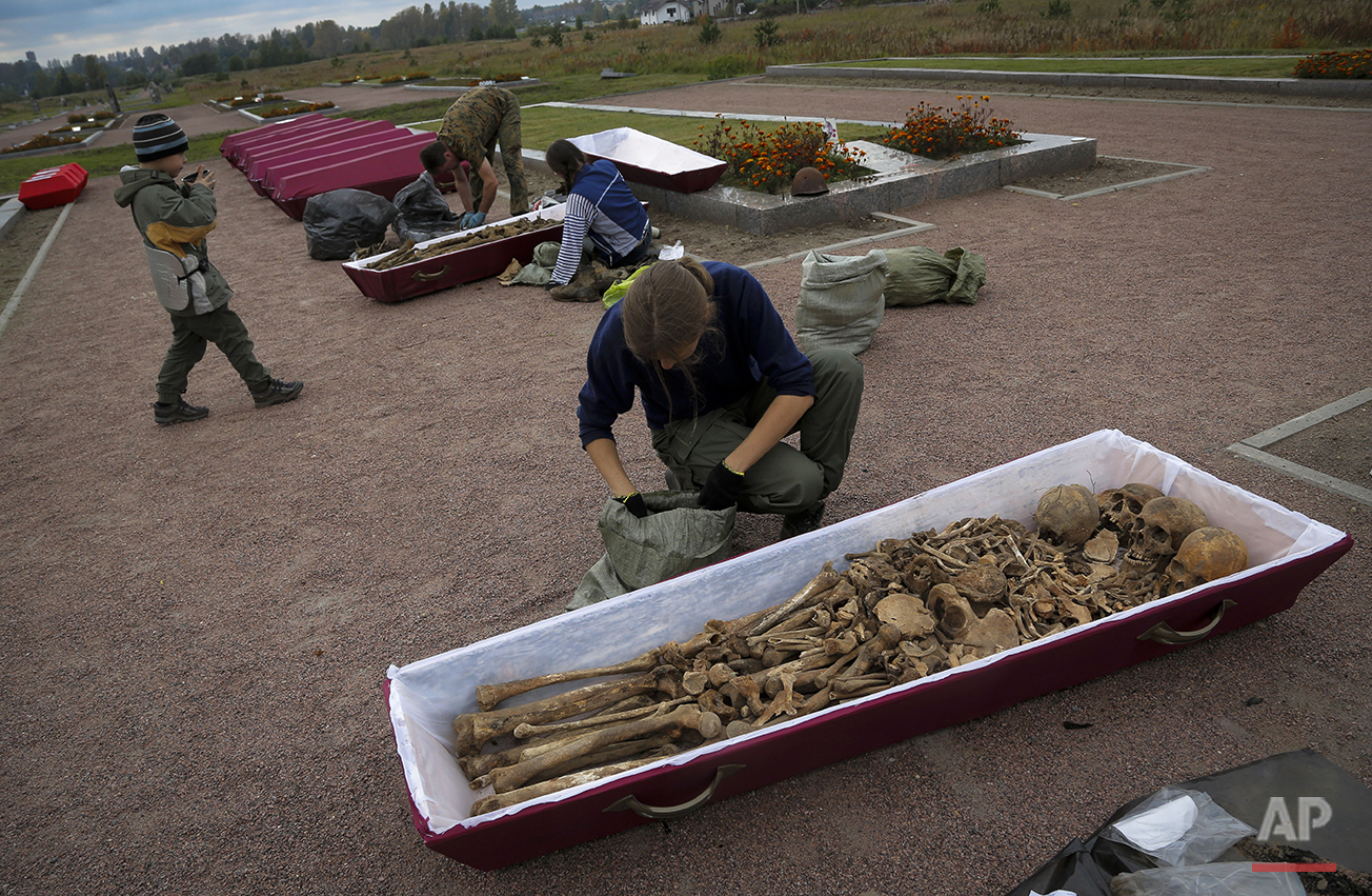  In this photo taken on Thursday, Sept.  17, 2015, members of a volunteer group searching for the remains of Soviet soldiers killed during WWII, put remains in coffins during preparation for burial in a memorial cemetery at Nevsky Pyatachok near Kiro