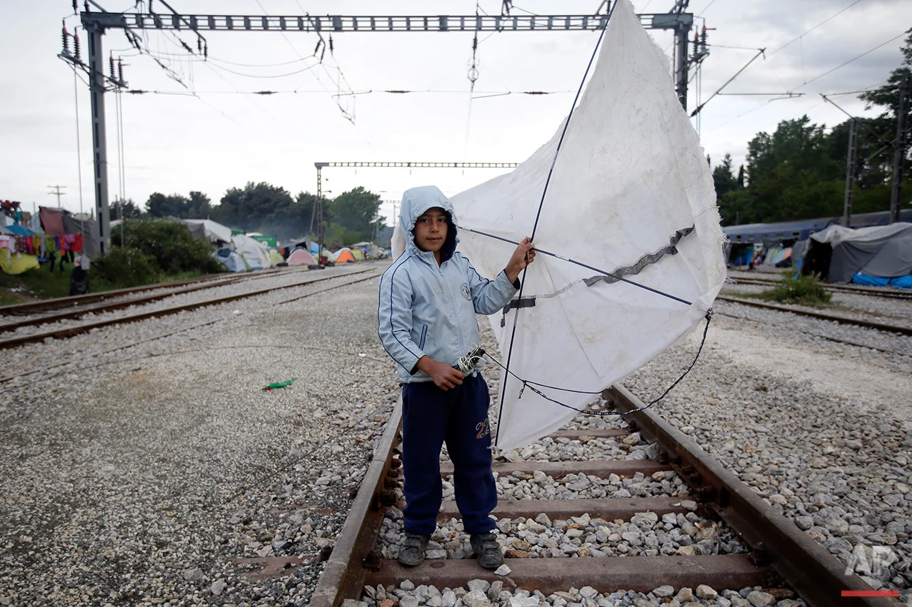 Yesa, 6, from Syria, holds his kite that he made with the sticks of a broken tent as he poses for a portrait on the tracks of a rail way station which was turned into a makeshift camp crowded by migrants and refugees at the northern Greek border point of Idomeni, Greece, Tuesday, May 3, 2016. At Greece’s blockaded border with Macedonia, 10,000 people who arrived hoping to start new lives farther west and north in Europe are settling instead into lives in limbo, sleeping in tents in mud and rain as they wait to find out what happens next. (AP Photo/Gregorio Borgia)