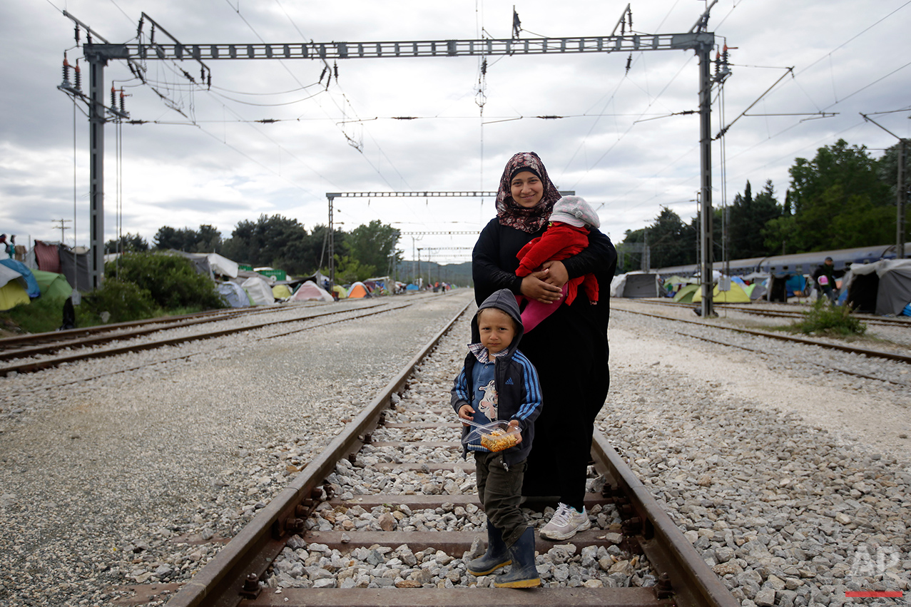  Syria's Mariam Shaudi, holds her 4-month-old baby, Aia, as she poses for a portrait together with her 5-year-old son Ali, on the tracks of a rail way station which was turned into a makeshift camp crowded by migrants and refugees at the northern Gre